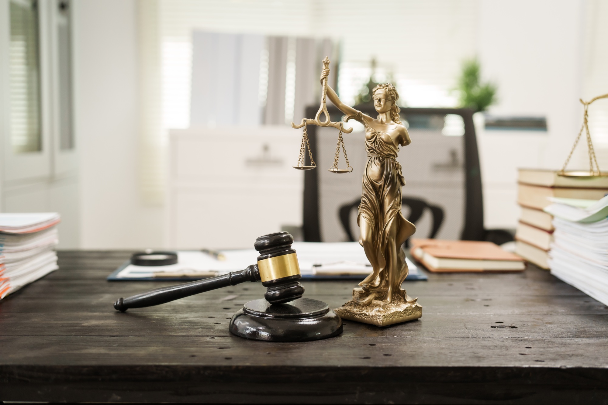 A lawyer's desk in the office is filled with legal documents.The lawyer provides consultations